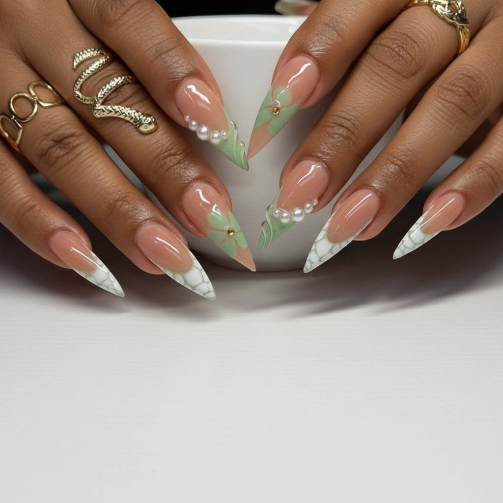 Aura27 press-on nails with French tips, green floral design, pearls, and snake accent. Stiletto shape.