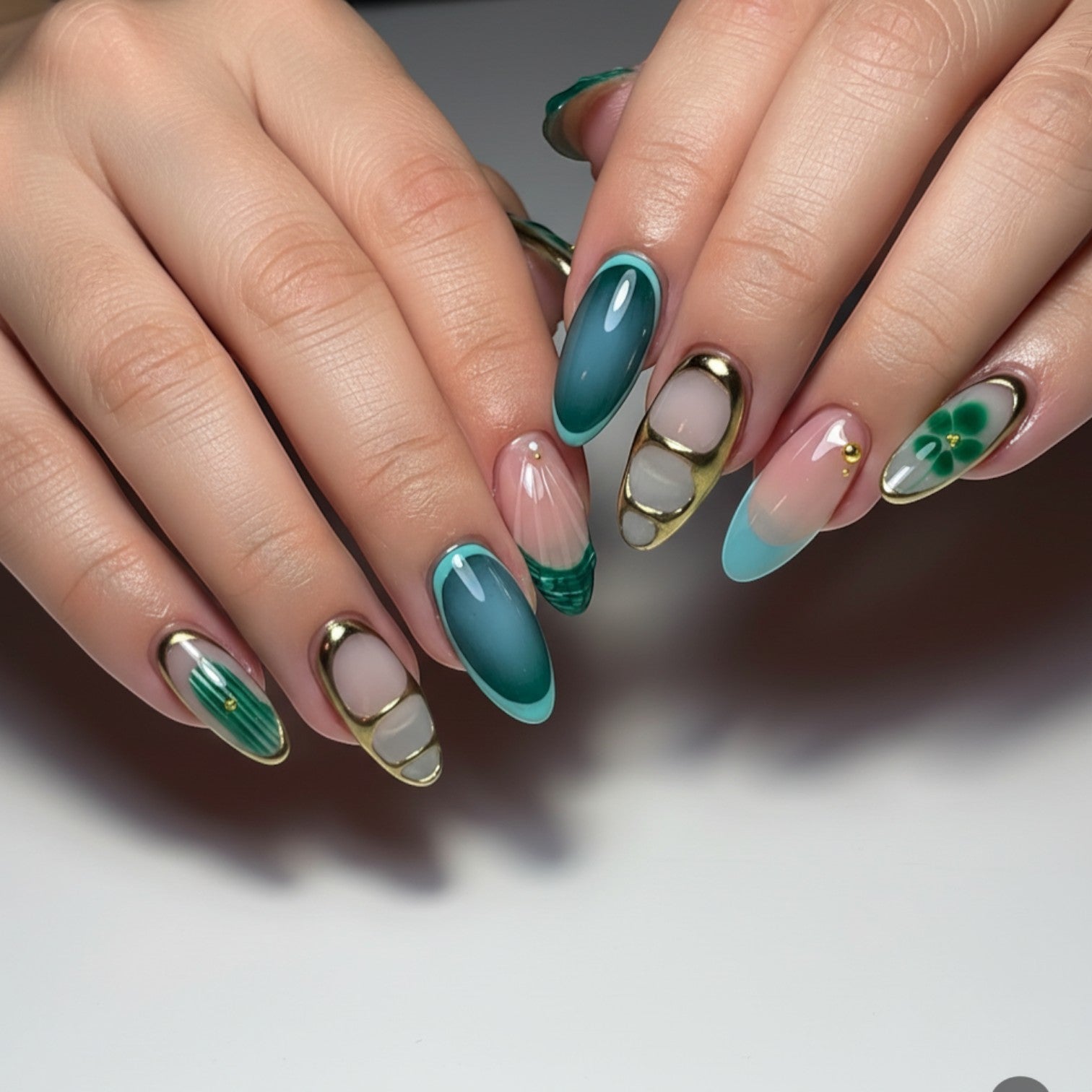 Aurapal Aura32 press-on nails with abstract green and blue designs, gold accents, and clover detail.