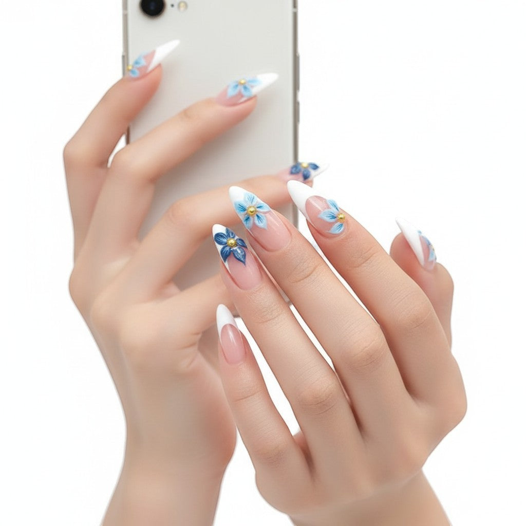 AuraPal French tip press-on nails with blue floral 3D accents and gold beads. Almond shape.