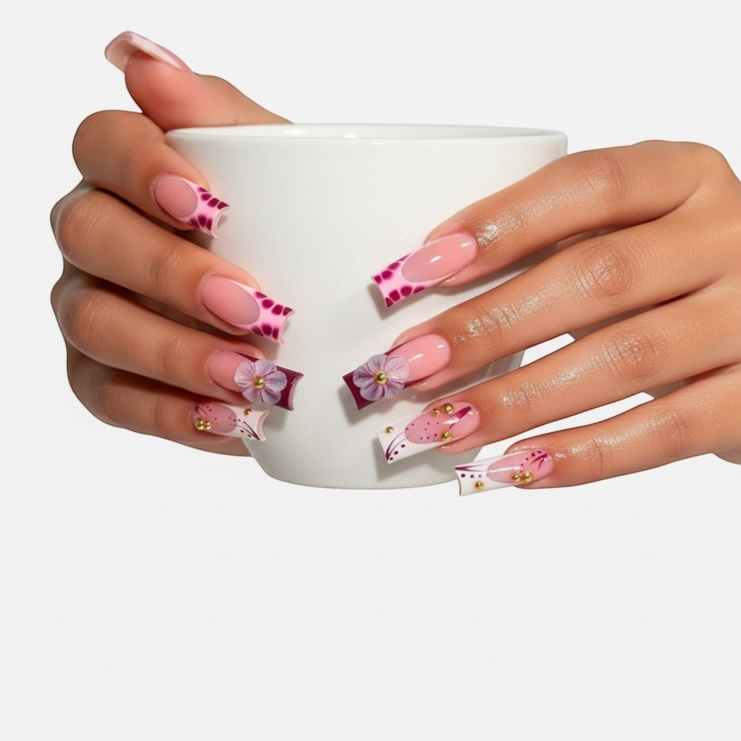 Aurapal long square press-on nails with nude base, berry floral patterns, 3D flowers, and gold studs holding a cup.