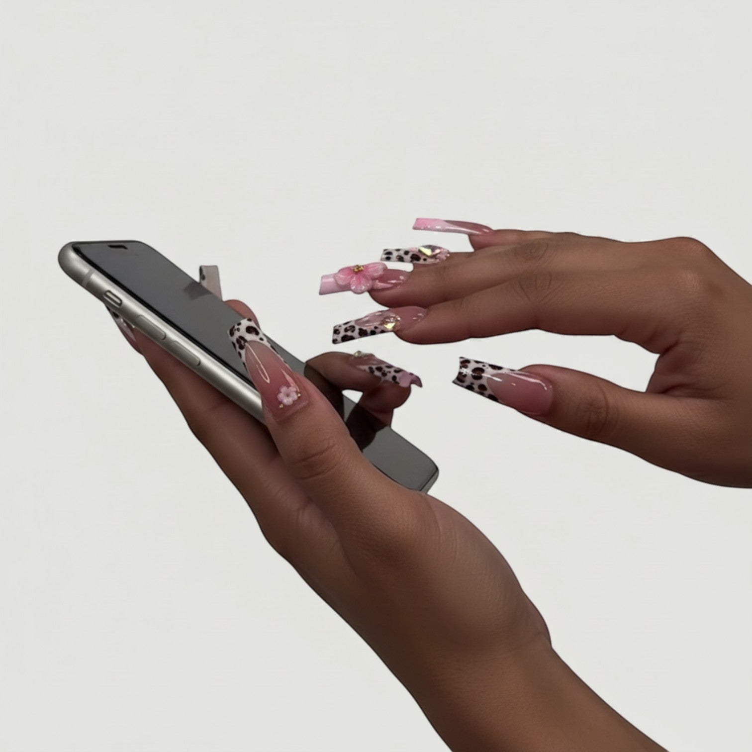 AuraPress54 long coffin press-on nails with pink ombre, leopard print French tips, 3D flowers, and rhinestones.