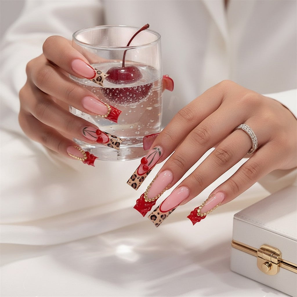 Aurapal long square press-on nails with red French tips, leopard print, cherry motifs, and rhinestone embellishments.