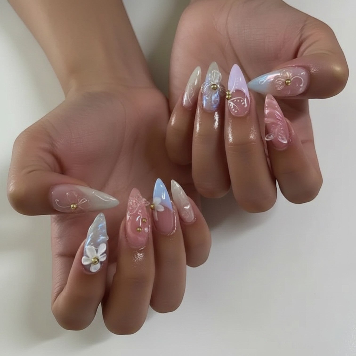 Press Aura42 by Aurapal: pastel press-on nails with 3D floral accents and gold bead details.
