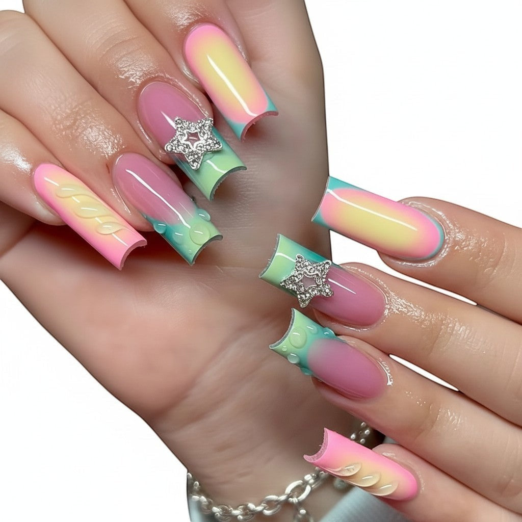 Aurapal square press-on nails with pastel gradient, star charms, 3D bubble accents, and cable-knit texture.
