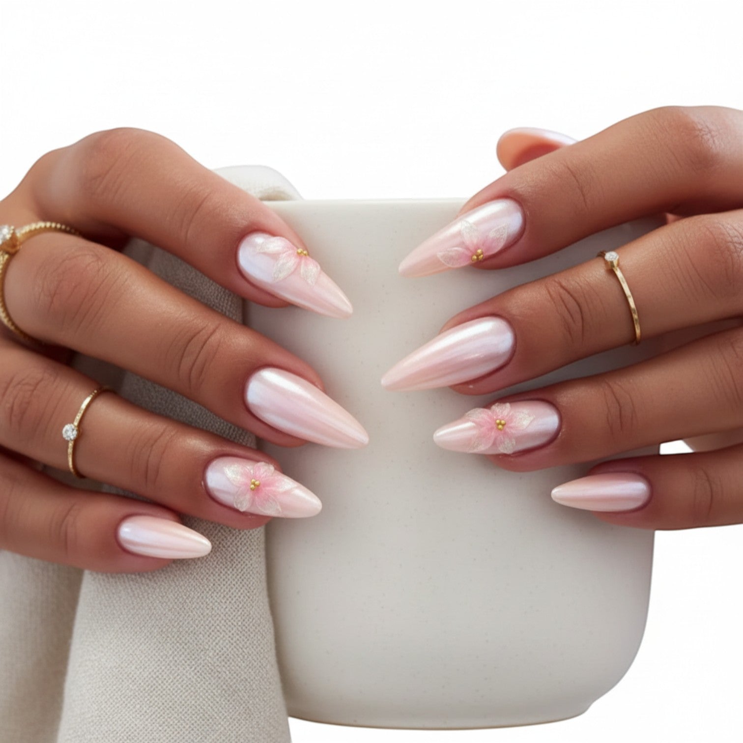 Aura35 press-on nails in pearlescent pink with delicate 3D floral accents and gold bead centers.