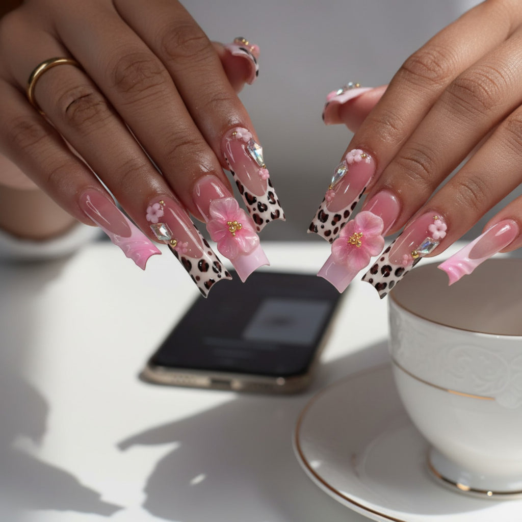 AuraPress54 long coffin press-on nails with pink ombre, leopard print French tips, 3D flowers, rhinestones, and gold beads.