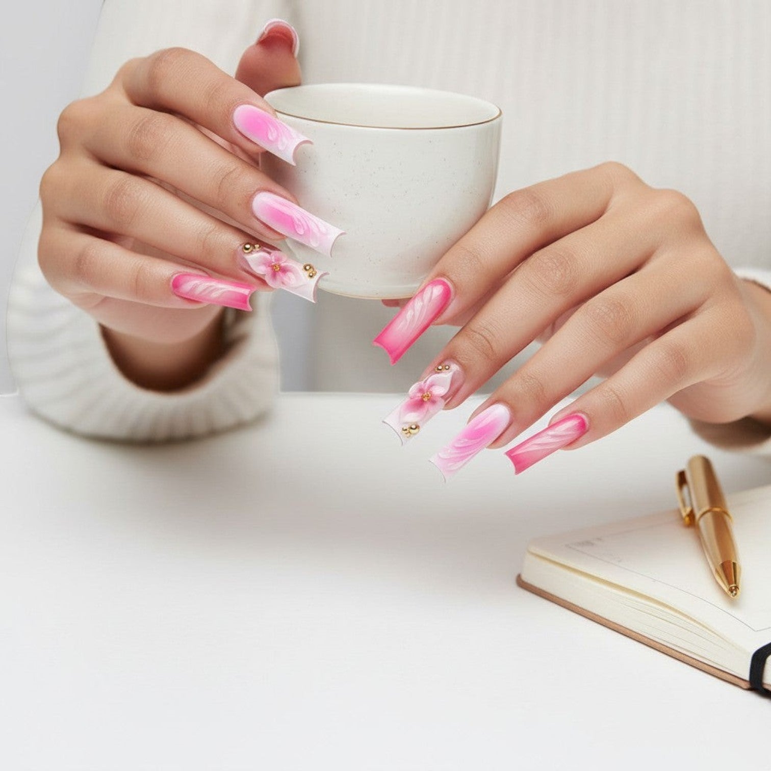 Aurapal Aura22 pink and white ombre press-on nails with 3D floral accents and gold beads.