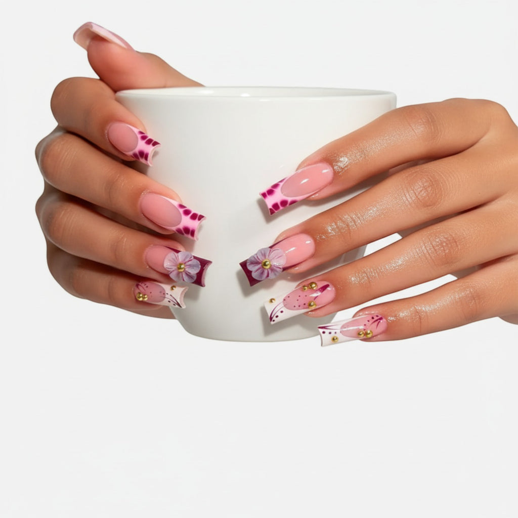 Press Aura51 pink French tip press-on nails with 3D flowers, gold beads, and abstract purple designs.