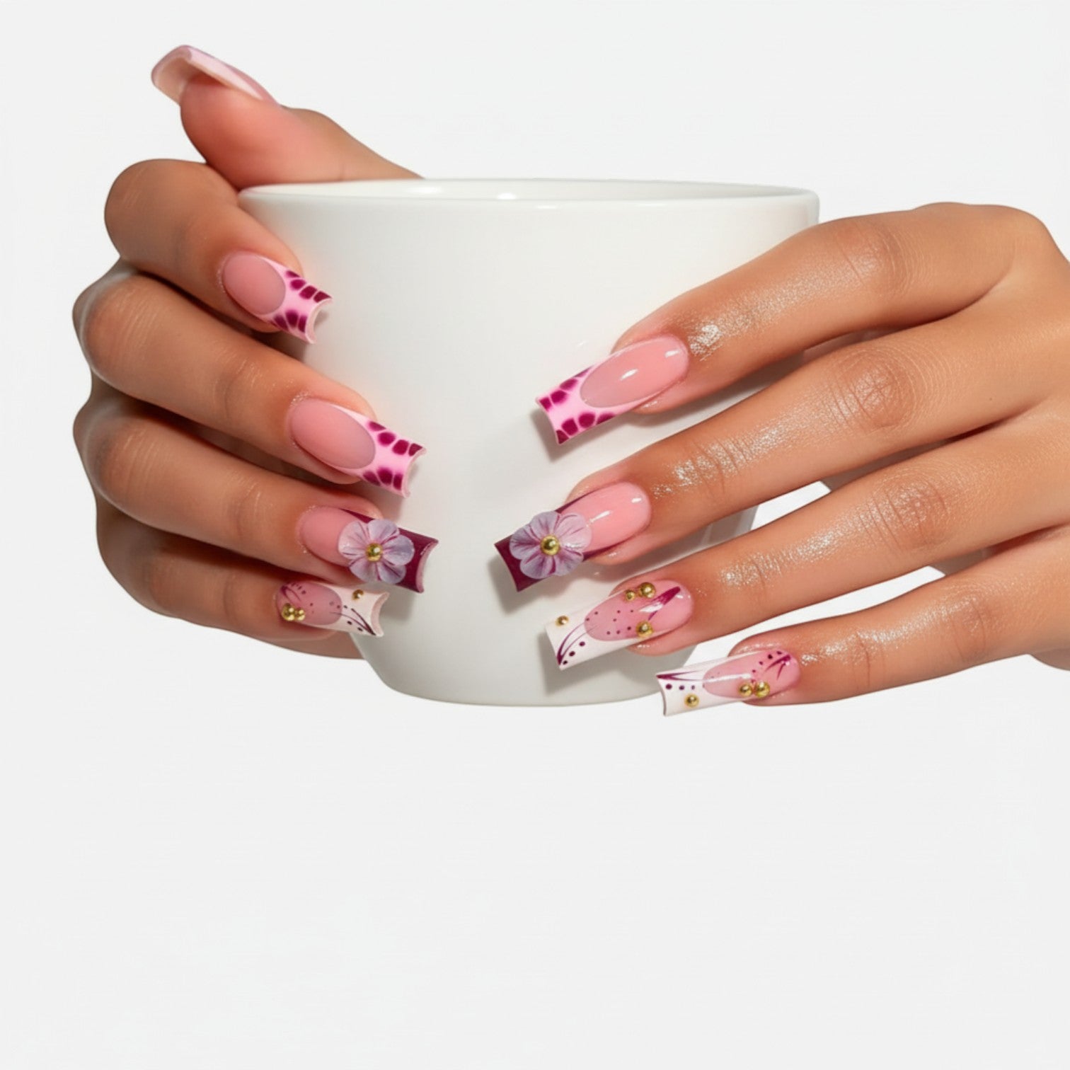 Press Aura51 pink French tip press-on nails with 3D flowers, gold beads, and abstract purple designs.