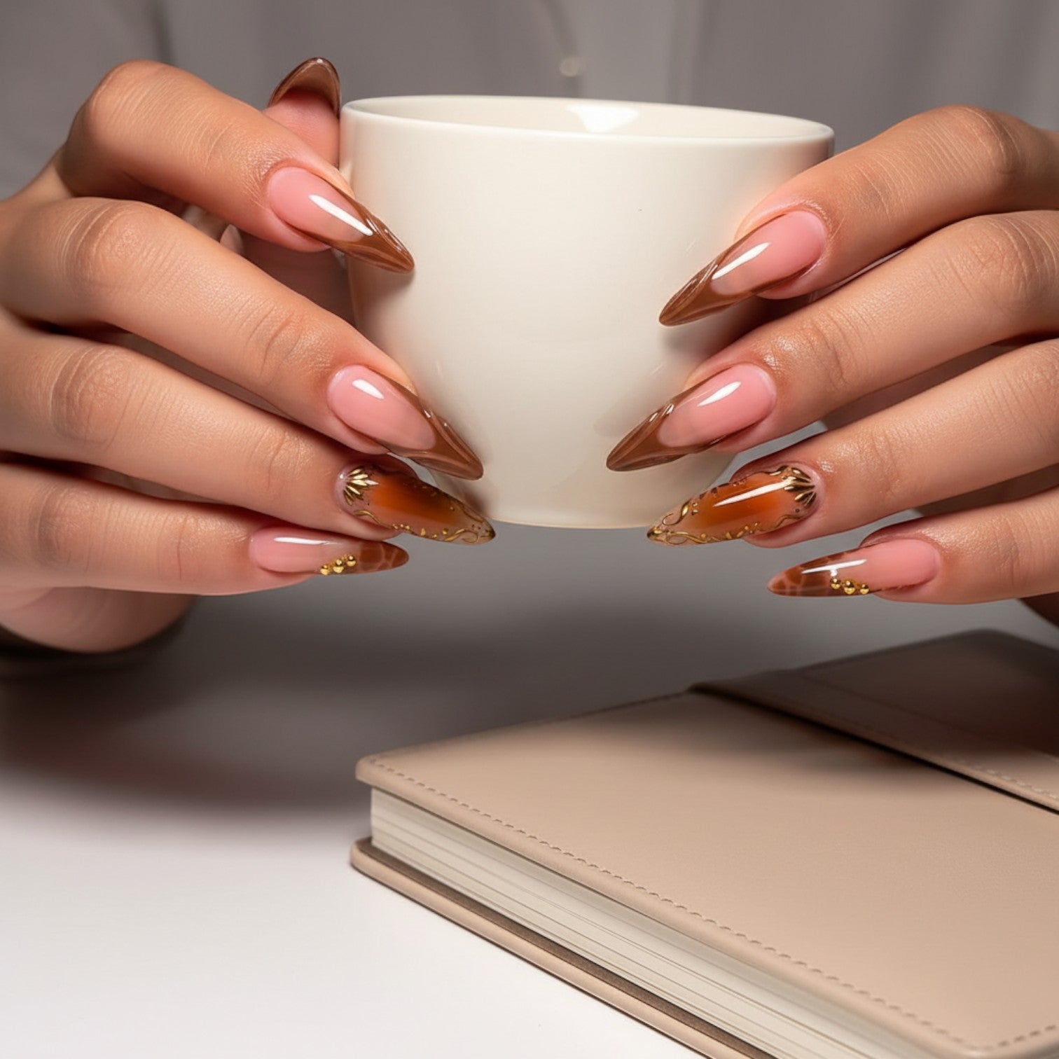 Press Aura36 stiletto press-on nails in pink and brown with gold accents and 3D embellishments.