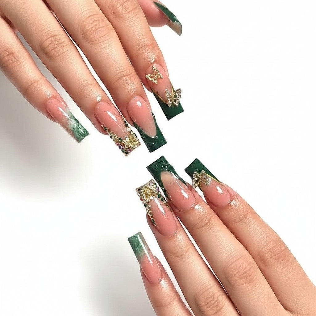 AuraPal Aura11 press-on nails: pink French tips with green accents, gold butterfly charms, and rhinestone embellishments.